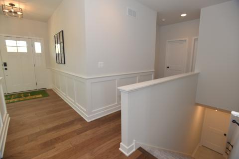 Craftsman style wainscoting with open stairway to basement