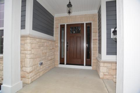 Craftsman fiberglass stainable front door with matching sidelights and stone water table