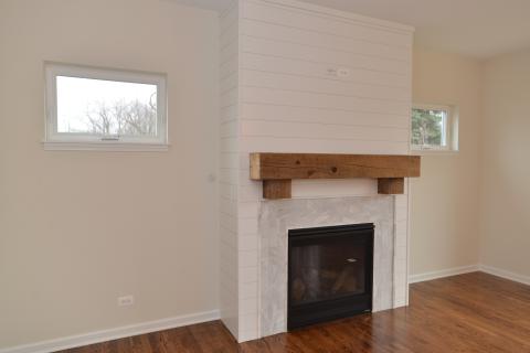 Custom fireplace surround with shiplap paneling and reclaimed wood mantle