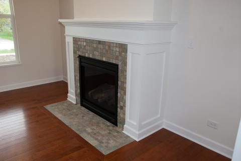 Fireplace with paneled mantle and stone tiles