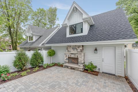 Rear courtyard patio with unattached garage and gas fireplace